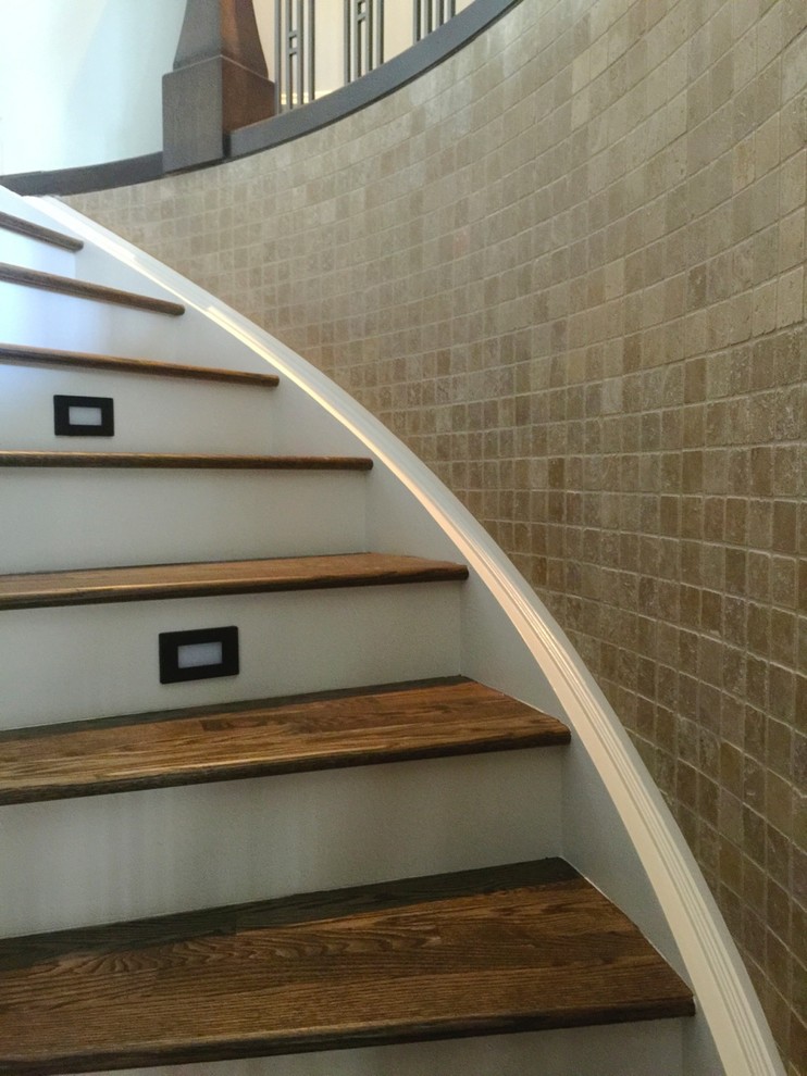 Идея дизайна: большая изогнутая лестница в стиле неоклассика (современная классика) с деревянными ступенями и крашенными деревянными подступенками