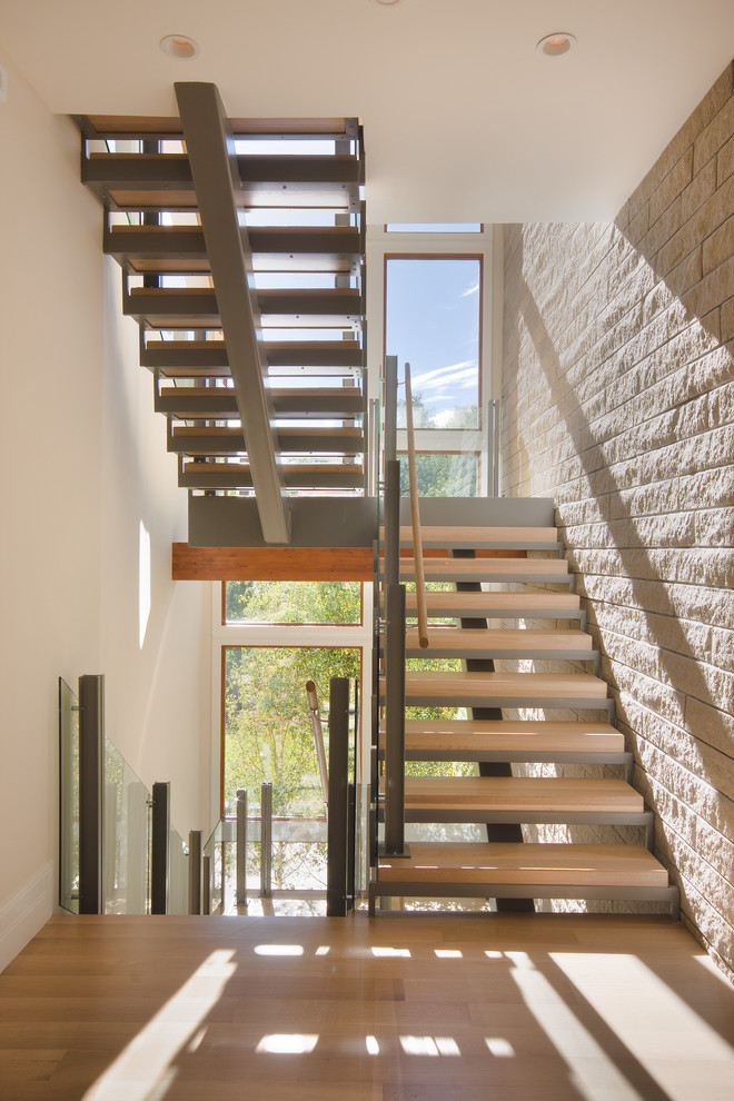 Aménagement d'un grand escalier sans contremarche contemporain en U avec des marches en bois, un garde-corps en matériaux mixtes et palier.