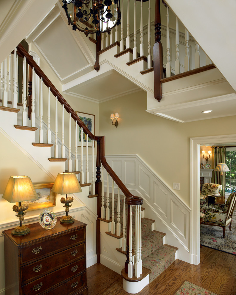 Large elegant wooden u-shaped staircase photo in Boston with painted risers
