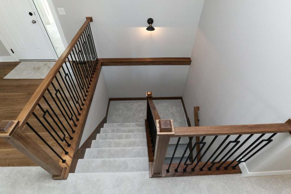 Diseño de escalera en U de estilo de casa de campo de tamaño medio con escalones enmoquetados, contrahuellas de hormigón y barandilla de madera