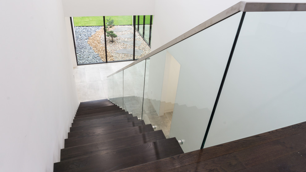 This is an example of a large contemporary wood straight staircase in Dallas with open risers.