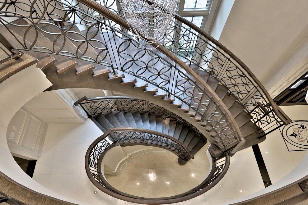 Example of a classic wooden curved open staircase design in Toronto