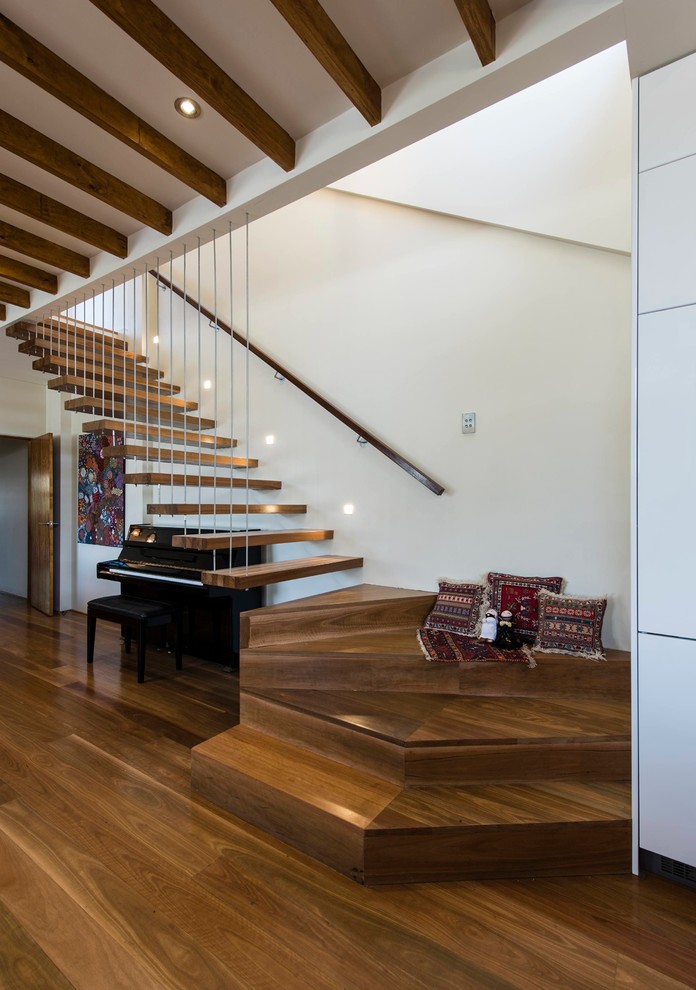 Diseño de escalera en L contemporánea sin contrahuella con escalones de madera y barandilla de madera