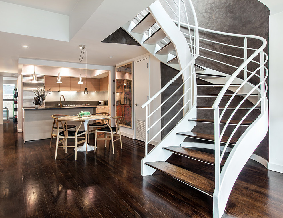 Trendy wooden curved open staircase photo in New York