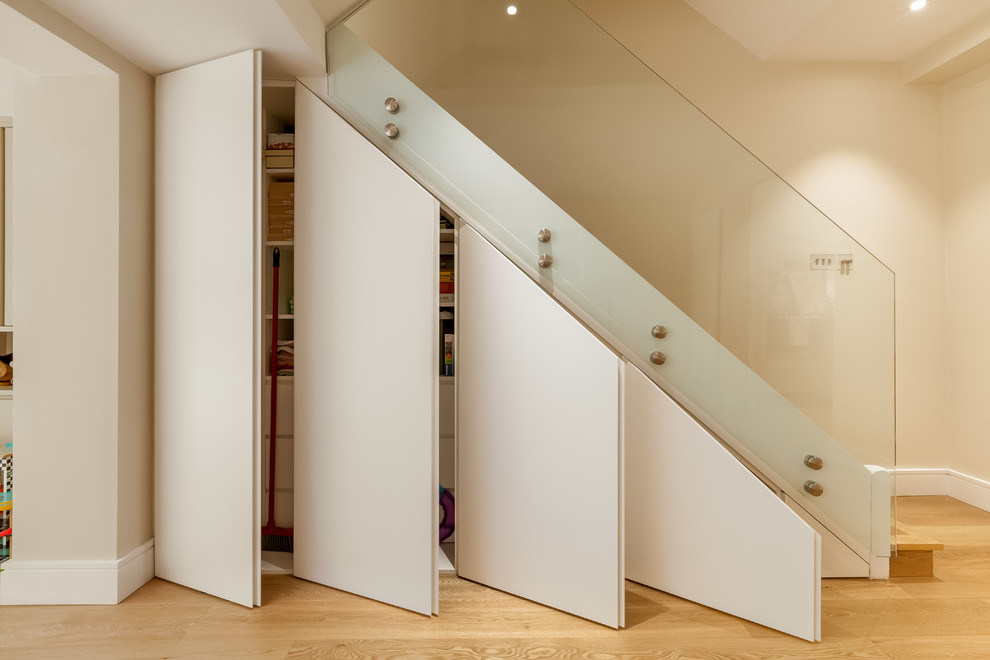 Свежая идея для дизайна: лестница среднего размера в современном стиле с стеклянными перилами и кладовкой или шкафом под ней - отличное фото интерьера