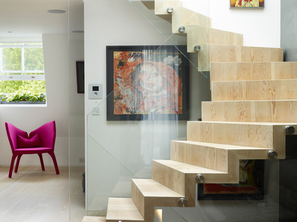 Foto de escalera de caracol actual de tamaño medio con escalones de madera, contrahuellas de madera y barandilla de vidrio