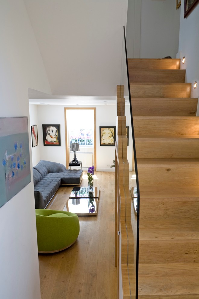 Imagen de escalera en U actual de tamaño medio con escalones de madera, contrahuellas de madera y barandilla de vidrio
