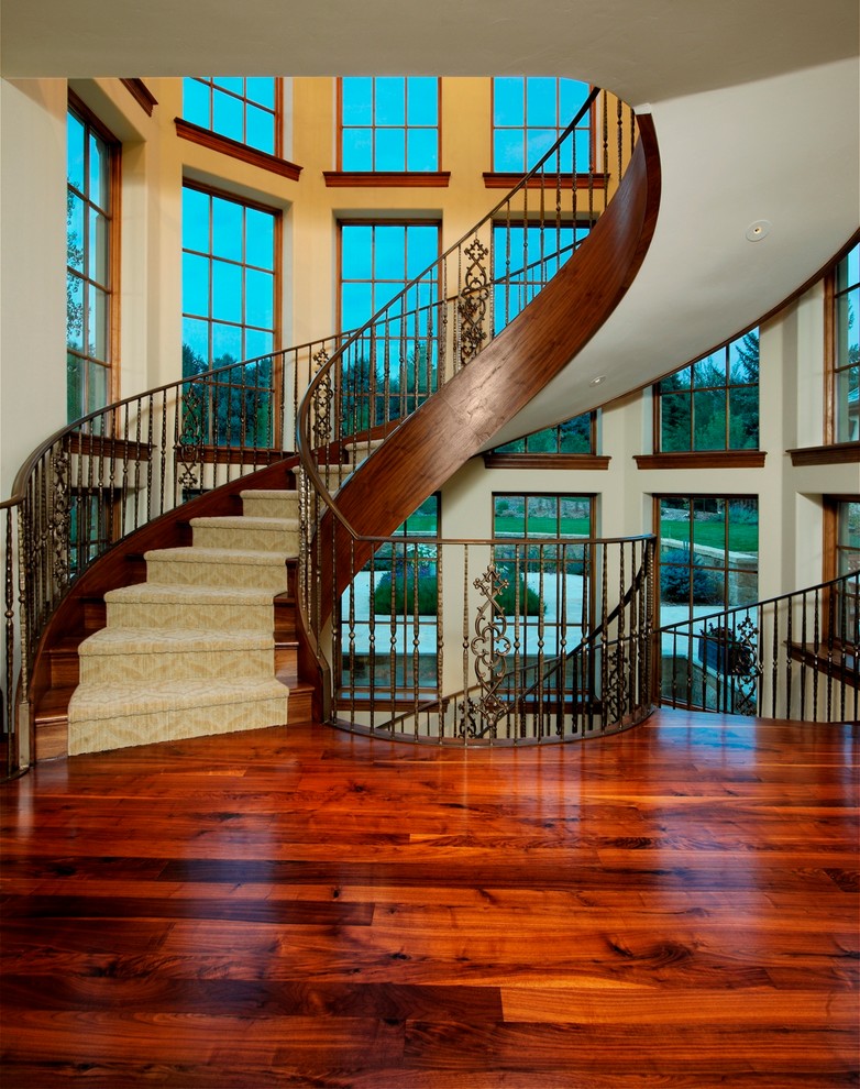 Design ideas for a classic wood curved staircase in Denver with wood risers.