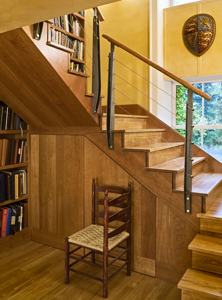 Aménagement d'un escalier contemporain avec des marches en bois, des contremarches en bois, un garde-corps en câble et rangements.
