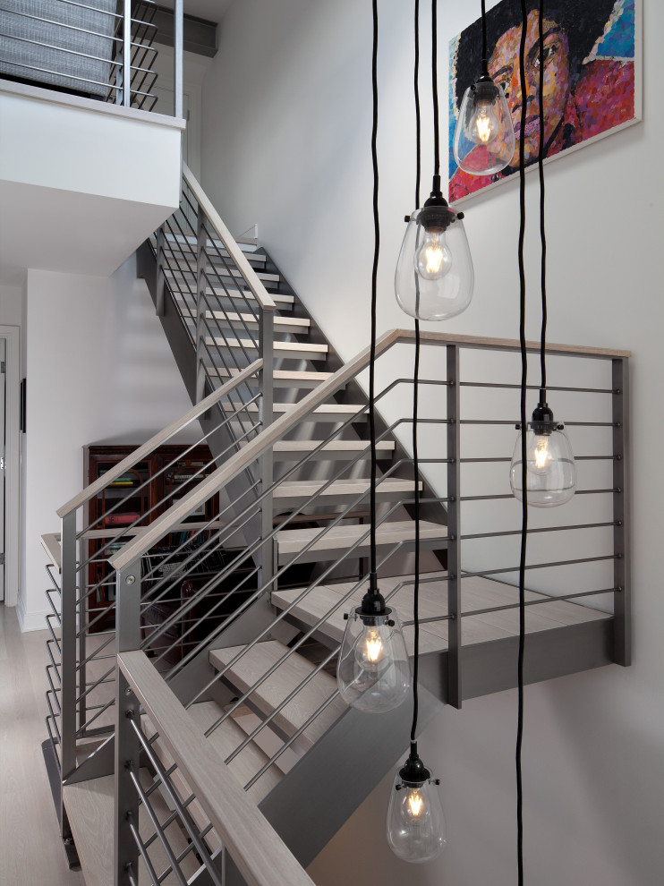 Diseño de escalera suspendida contemporánea sin contrahuella con escalones de madera y barandilla de metal