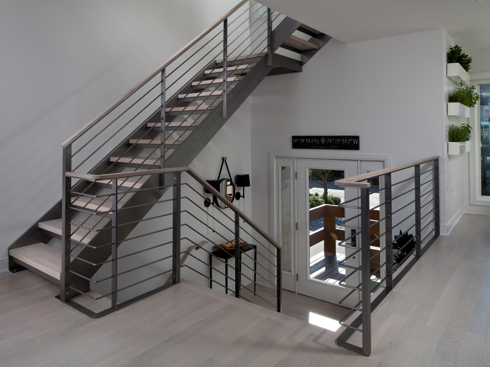 Diseño de escalera suspendida actual sin contrahuella con escalones de madera y barandilla de metal