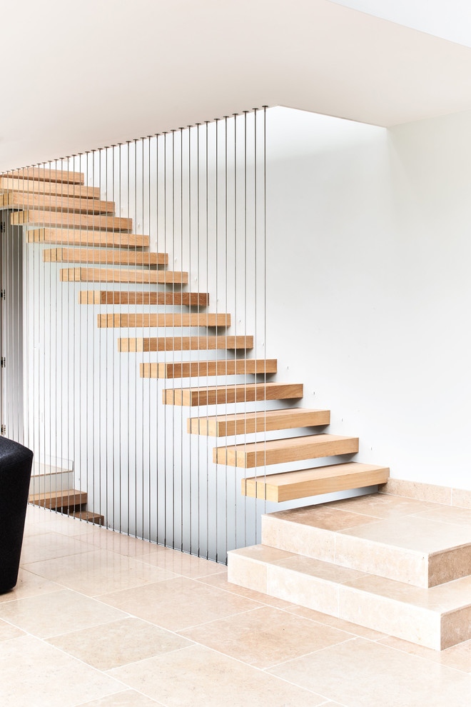 Ejemplo de escalera suspendida contemporánea sin contrahuella con escalones de madera y barandilla de cable