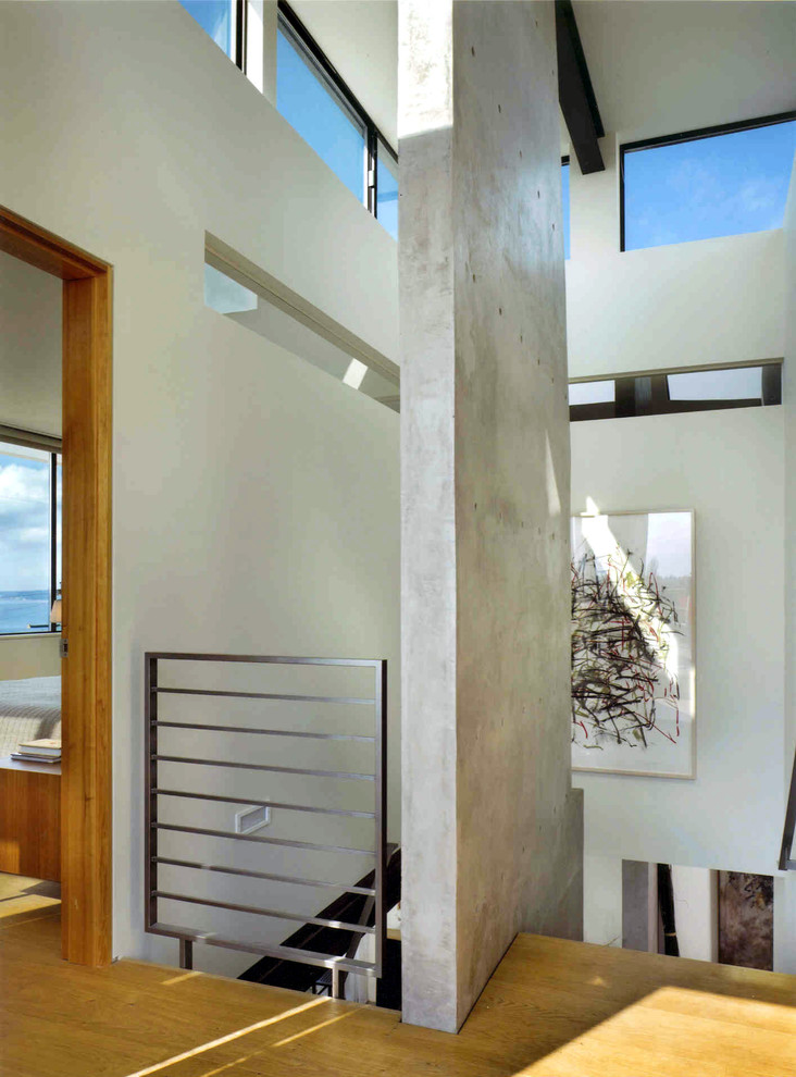 Diseño de escalera recta moderna grande con escalones de madera, contrahuellas de madera y barandilla de metal