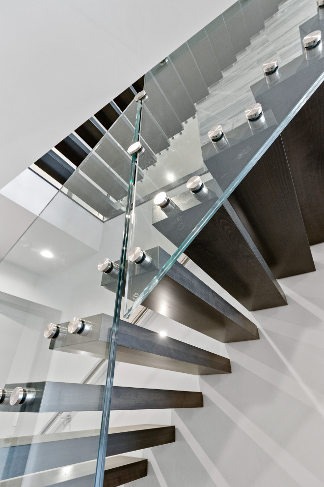 Идея дизайна: лестница на больцах в современном стиле с деревянными ступенями и стеклянными перилами без подступенок
