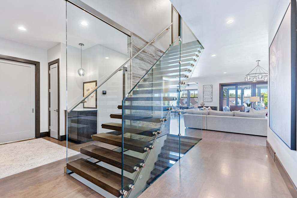 Inspiration for a contemporary wood floating glass railing staircase in Other with open risers.