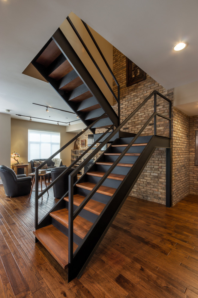 Idée de décoration pour un grand escalier design en U avec des marches en bois, des contremarches en métal et éclairage.
