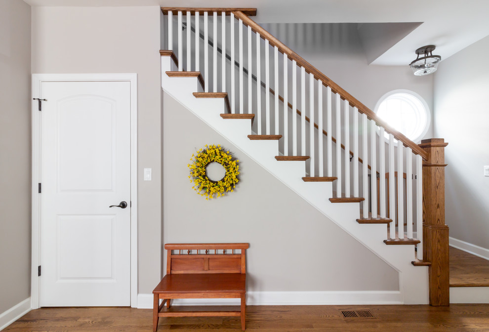 Photo of a shabby-chic style wood straight wood railing staircase in Boston with painted wood risers and feature lighting.