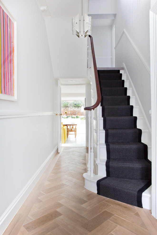Пример оригинального дизайна: изогнутая лестница среднего размера в современном стиле с крашенными деревянными ступенями, ковровыми подступенками и деревянными перилами