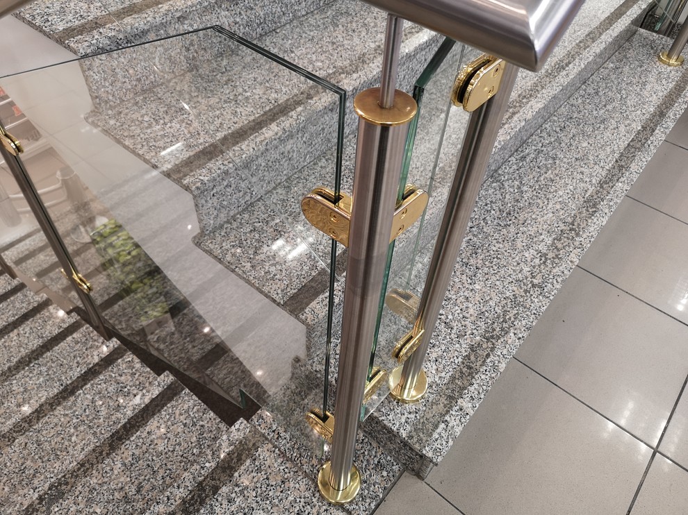 Ejemplo de escalera recta minimalista pequeña con escalones de vidrio, contrahuellas de metal y barandilla de metal