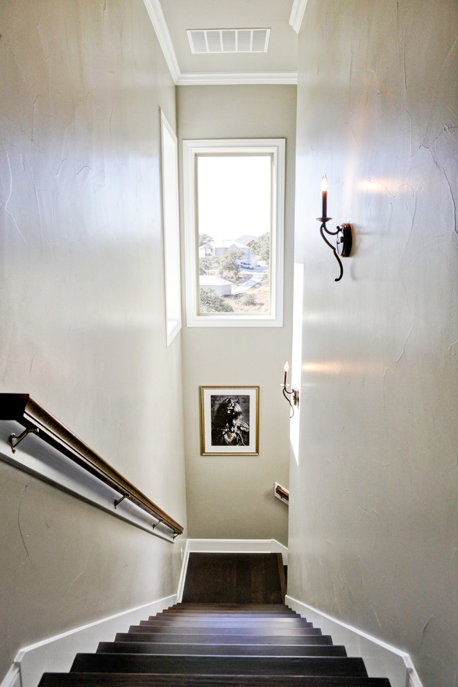 オースティンにある小さなトランジショナルスタイルのおしゃれなかね折れ階段 (木の蹴込み板、木材の手すり) の写真