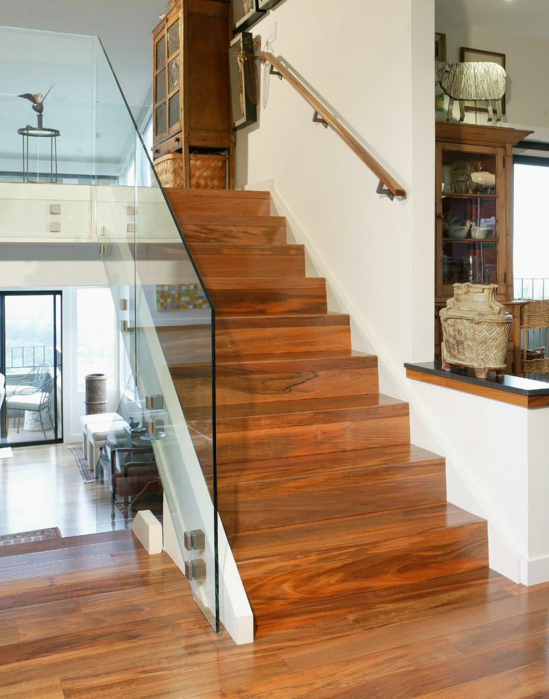 Ejemplo de escalera recta tradicional renovada grande con escalones de madera, contrahuellas de madera y barandilla de vidrio