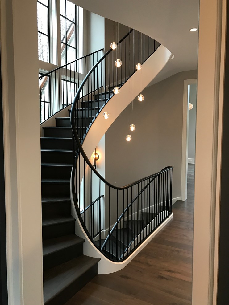 Пример оригинального дизайна: огромная винтовая лестница в современном стиле с крашенными деревянными ступенями, крашенными деревянными подступенками и металлическими перилами