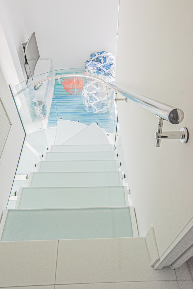 На фото: п-образная лестница среднего размера в морском стиле с стеклянными ступенями и стеклянными перилами без подступенок с