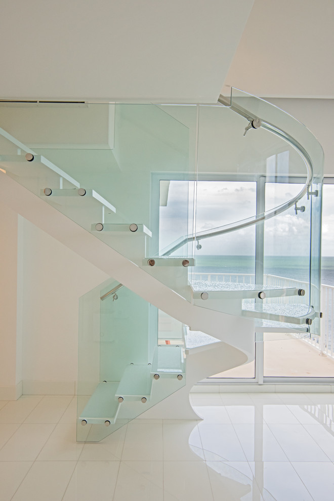 На фото: п-образная лестница среднего размера в морском стиле с стеклянными ступенями и стеклянными перилами без подступенок