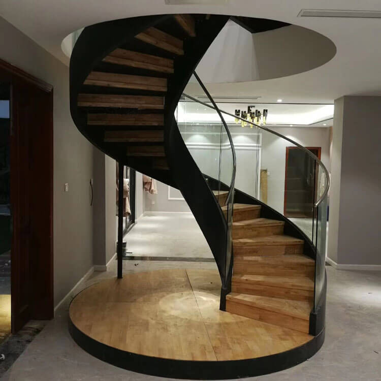 Aménagement d'un escalier courbe moderne de taille moyenne avec des marches en bois, des contremarches en bois et un garde-corps en verre.