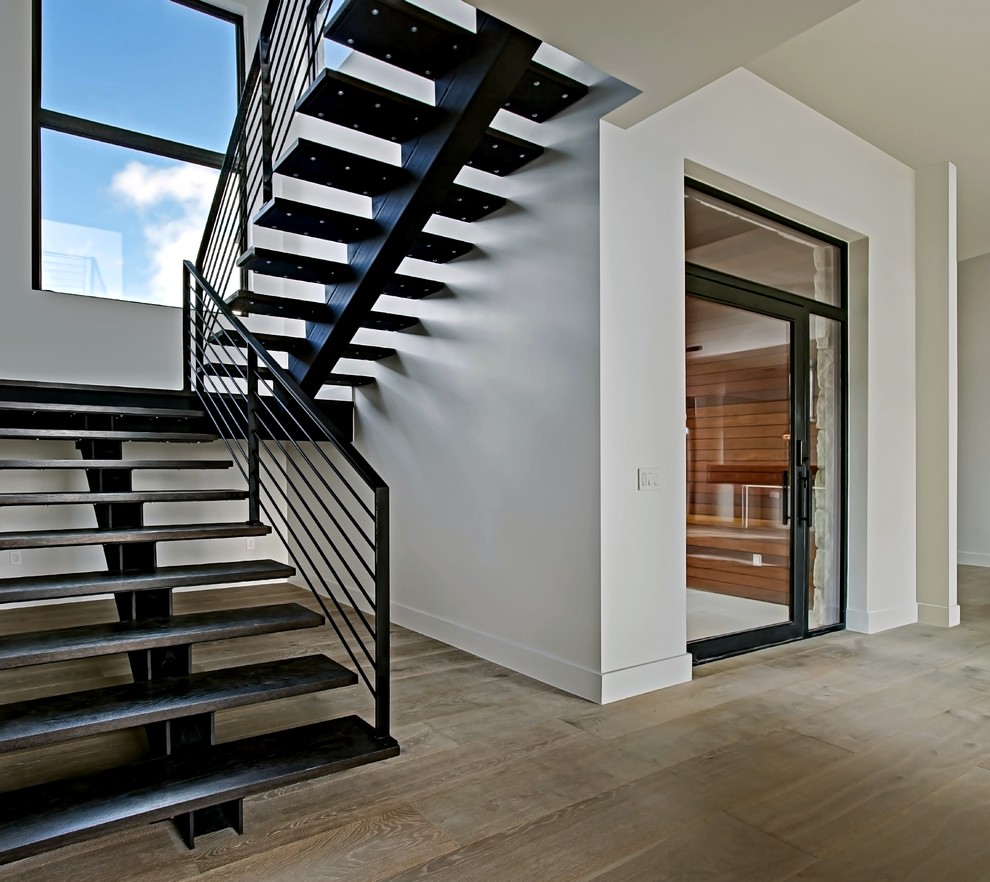 Large trendy metal u-shaped open and metal railing staircase photo in Austin