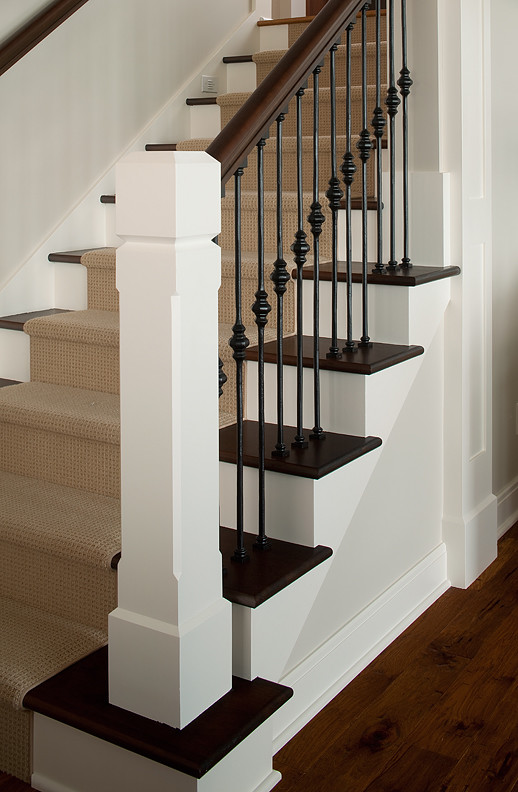 Large elegant wooden u-shaped staircase photo in Grand Rapids with painted risers