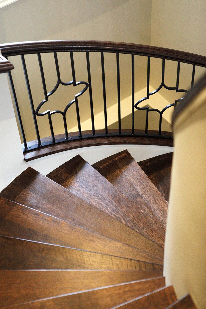 Cette photo montre un grand escalier courbe chic avec des marches en bois.