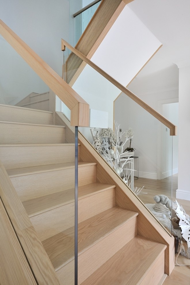Inspiration pour un escalier courbe traditionnel de taille moyenne avec des marches en bois, des contremarches en verre et un garde-corps en bois.