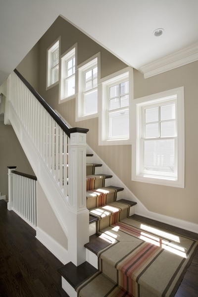 Diseño de escalera en L clásica de tamaño medio con escalones de madera y contrahuellas de madera pintada