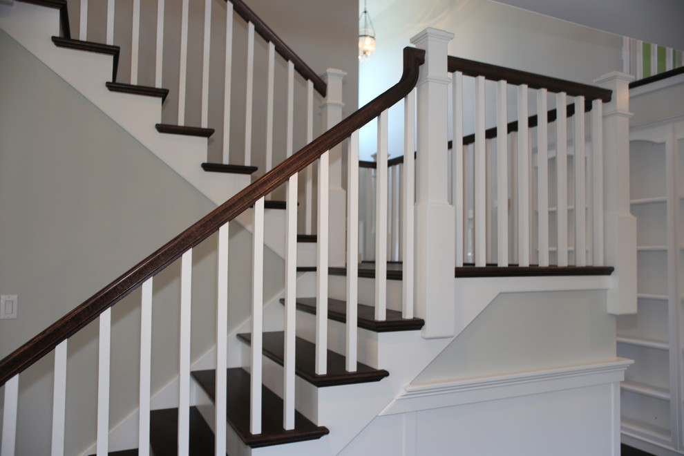 Idée de décoration pour un grand escalier craftsman en U avec des marches en bois et des contremarches en bois.