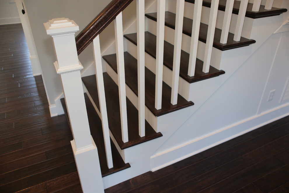 Ejemplo de escalera en U de estilo americano grande con escalones de madera y contrahuellas de madera