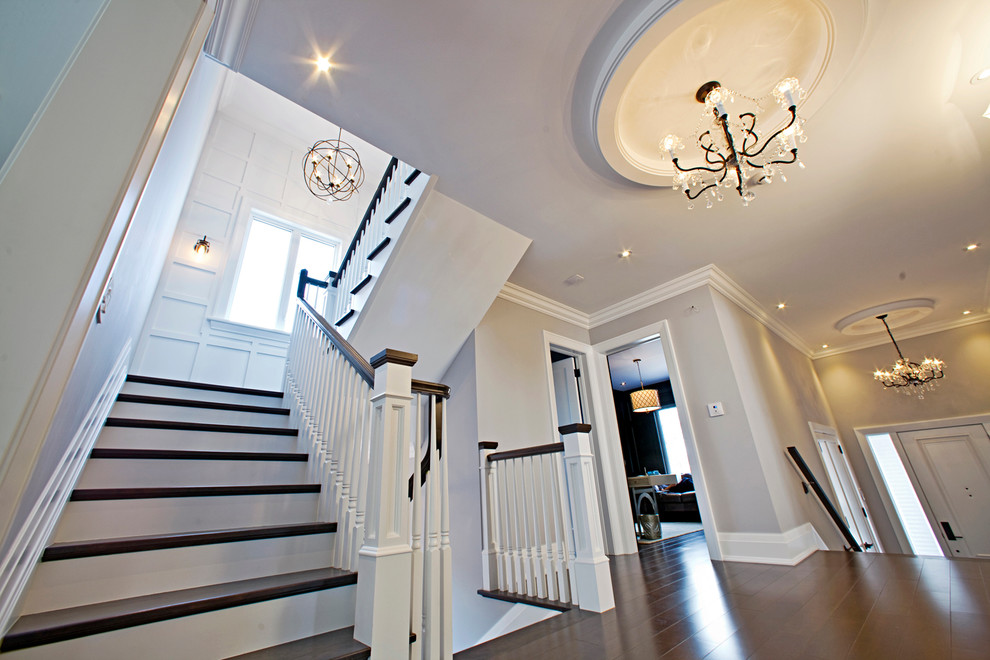 Idée de décoration pour un grand escalier droit tradition avec des marches en bois et des contremarches en bois.