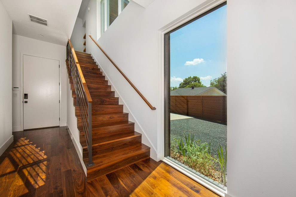 Diseño de escalera recta retro de tamaño medio con escalones de madera, contrahuellas de madera y barandilla de varios materiales