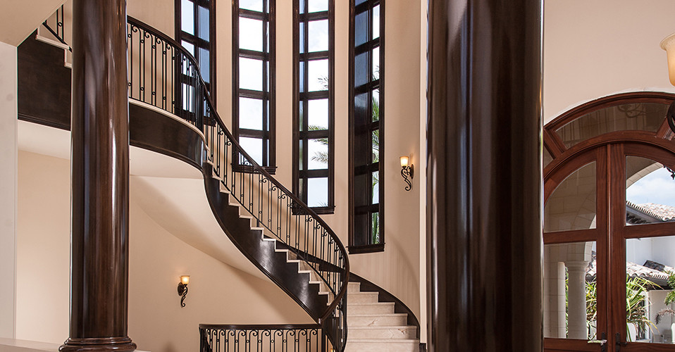 Пример оригинального дизайна: огромная изогнутая лестница в классическом стиле с ступенями из плитки и подступенками из плитки