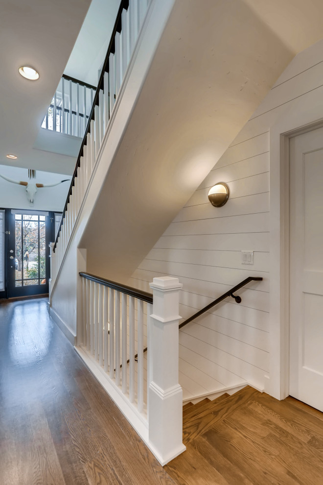 Mid-sized farmhouse wood railing and shiplap wall staircase photo in Denver with wooden risers