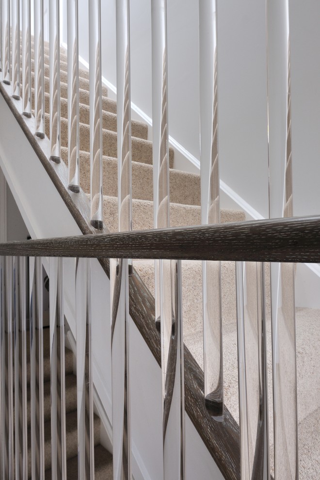 На фото: прямая деревянная лестница среднего размера в современном стиле с ступенями с ковровым покрытием и деревянными перилами
