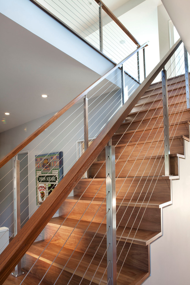 中くらいなモダンスタイルのおしゃれな直階段 (ワイヤーの手すり、木の蹴込み板) の写真