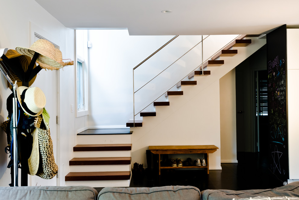 Foto de escalera en L minimalista pequeña con escalones de madera y contrahuellas de madera pintada