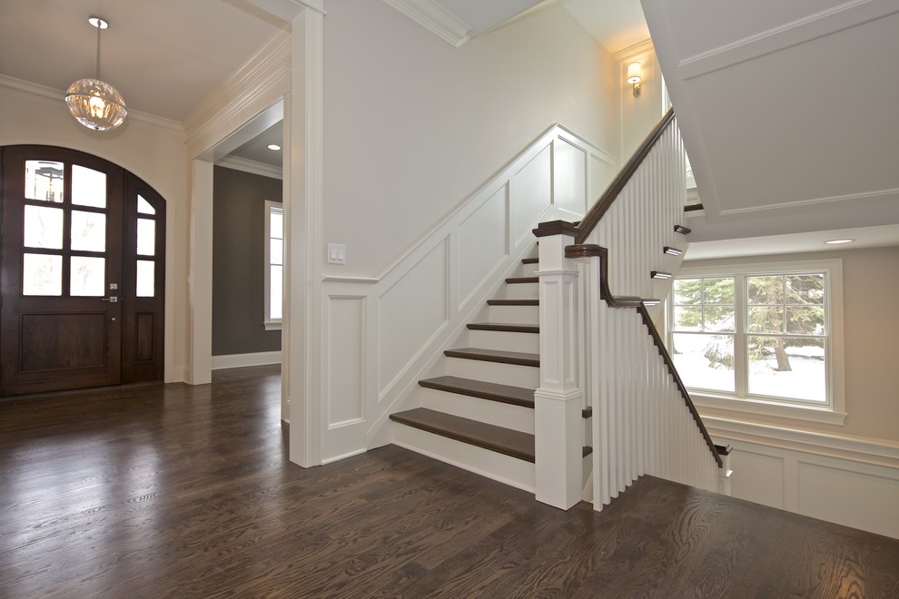 Photo of a medium sized coastal wood u-shaped staircase in Chicago with painted wood risers.