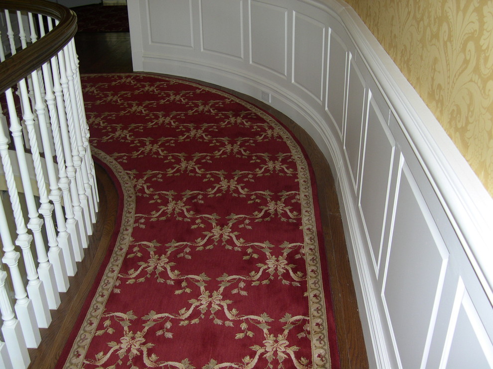 This is an example of a medium sized traditional carpeted curved wood railing staircase in New York with carpeted risers.