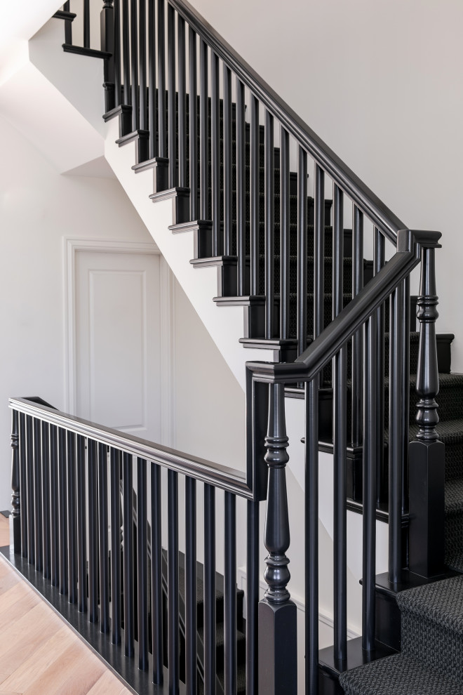 Medium sized traditional wood u-shaped wood railing staircase in Calgary with wood risers.