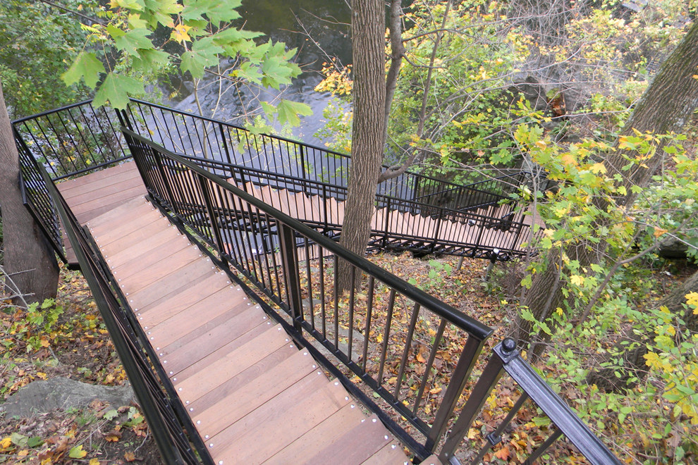 Cette photo montre un grand escalier chic en L avec des marches en métal et des contremarches en bois.