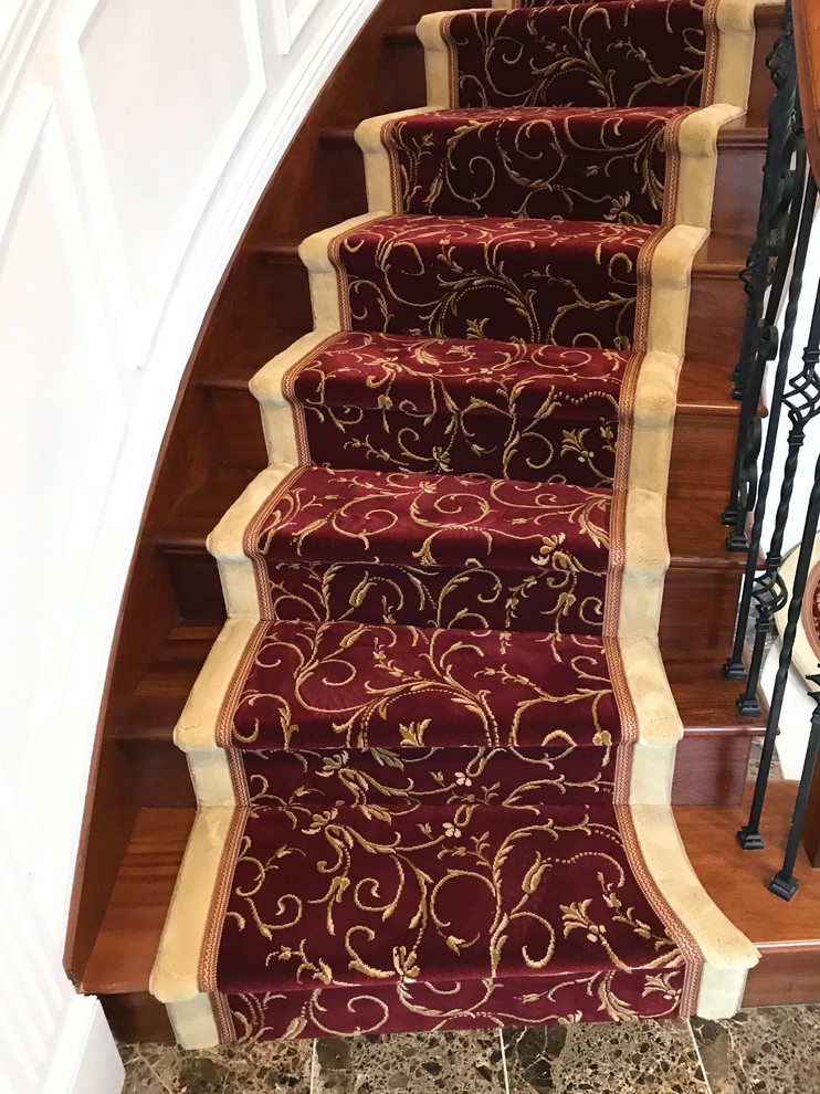 Imagen de escalera curva clásica renovada grande con escalones de madera, contrahuellas de madera y barandilla de varios materiales
