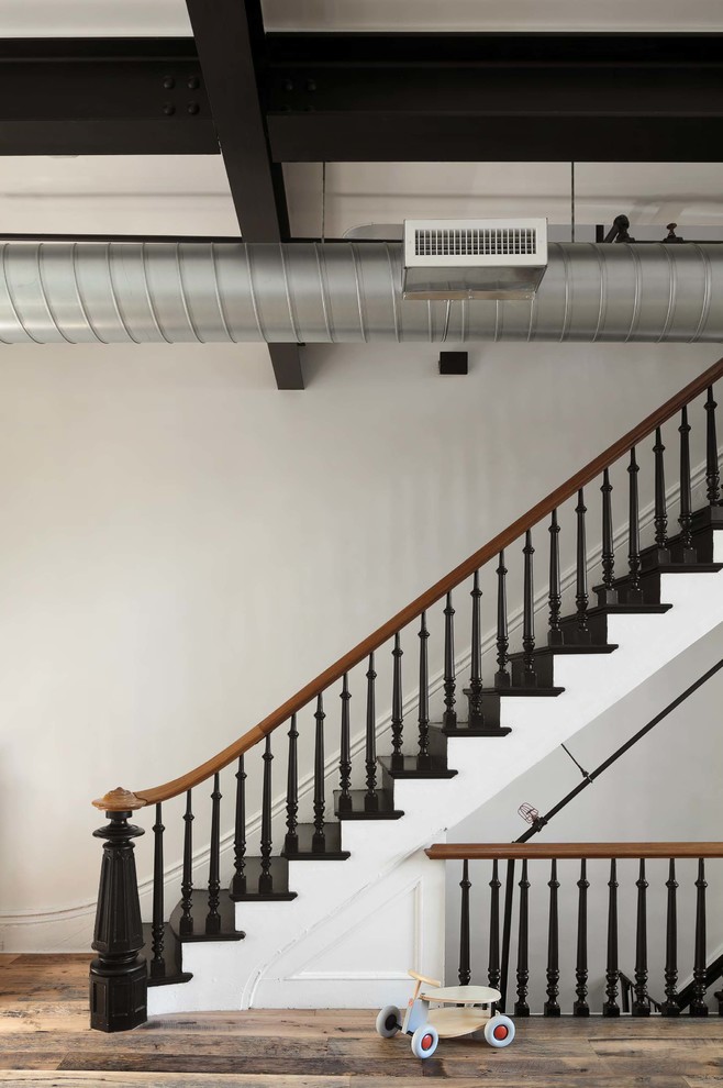 ニューヨークにある中くらいなインダストリアルスタイルのおしゃれな直階段 (木材の手すり、フローリングの蹴込み板) の写真