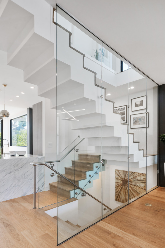 Inspiration for a medium sized contemporary wood u-shaped glass railing staircase in San Francisco with wood risers.